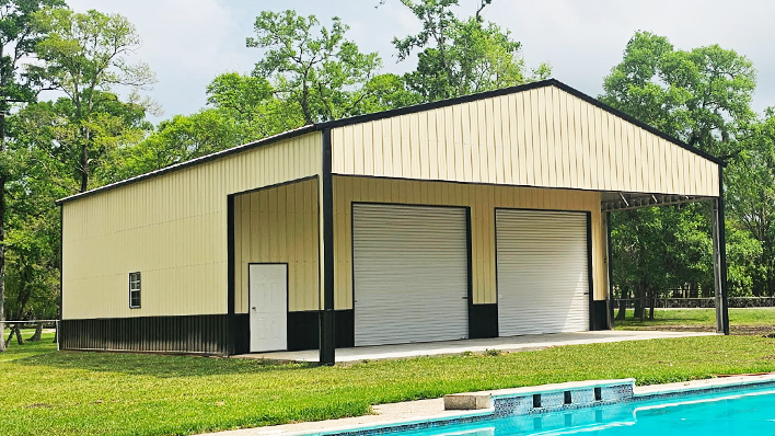 Light tan two-story metal barndominium with covered wraparound porch in Arkansas