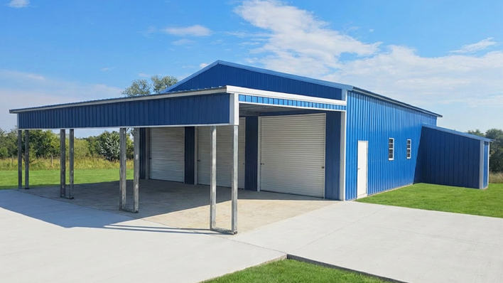 Modern blue and white steel barndominium with attached carport